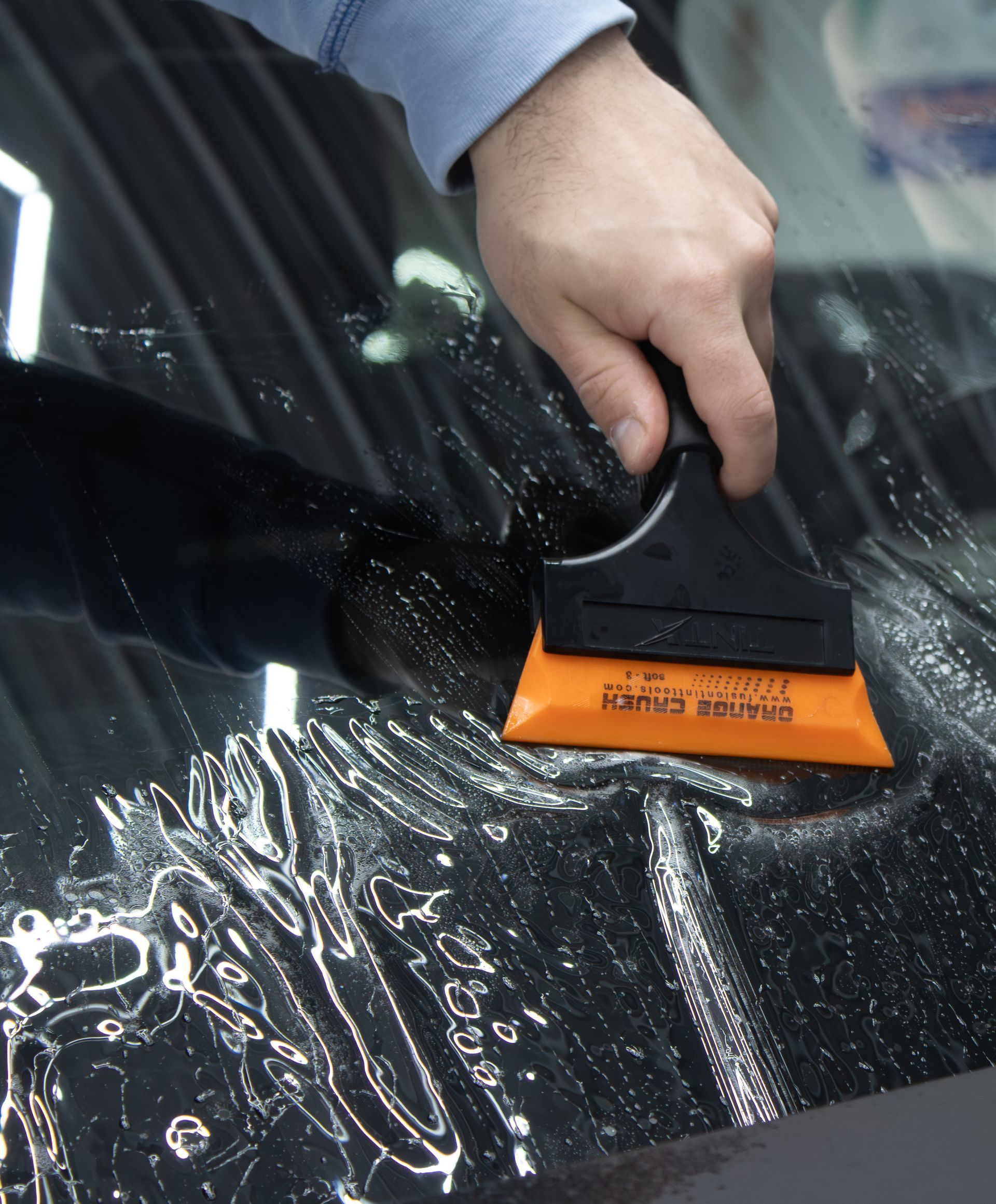 A person is cleaning a car with a spray bottle.