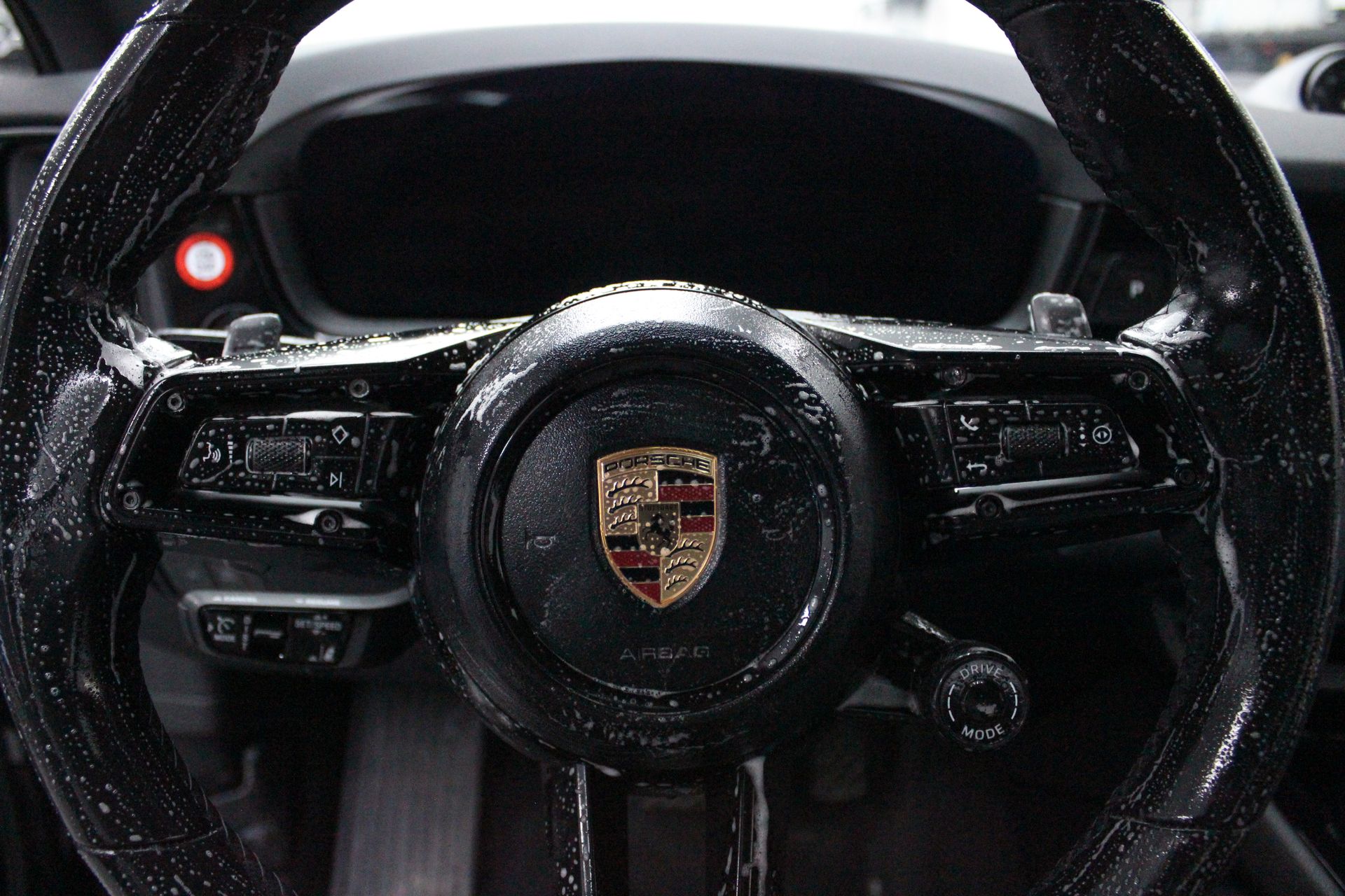A person is cleaning the interior of a car with a brush.