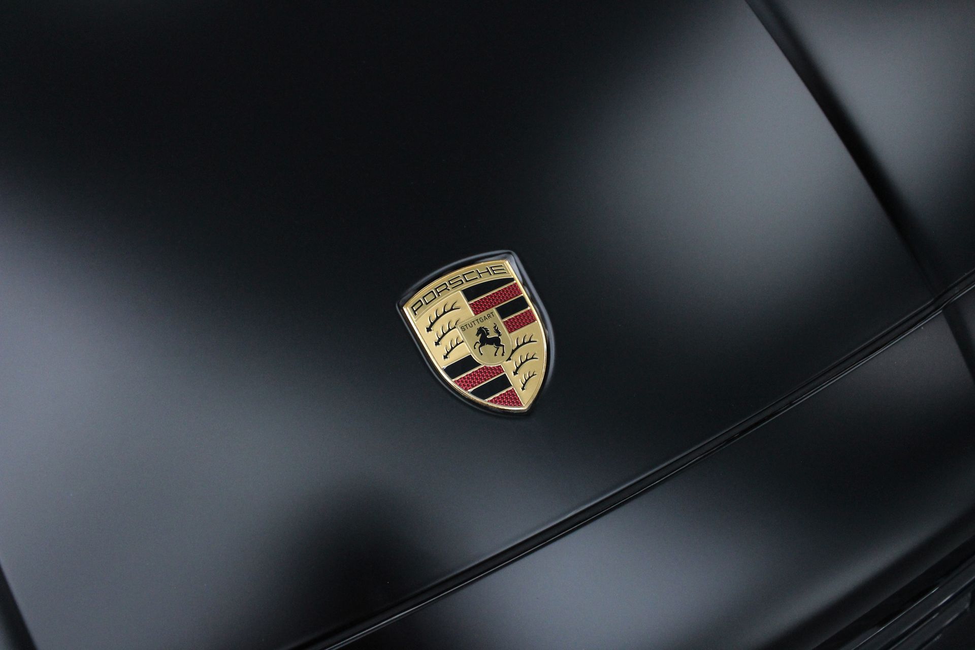 A close up of a black car with a yellow g on the front bumper.