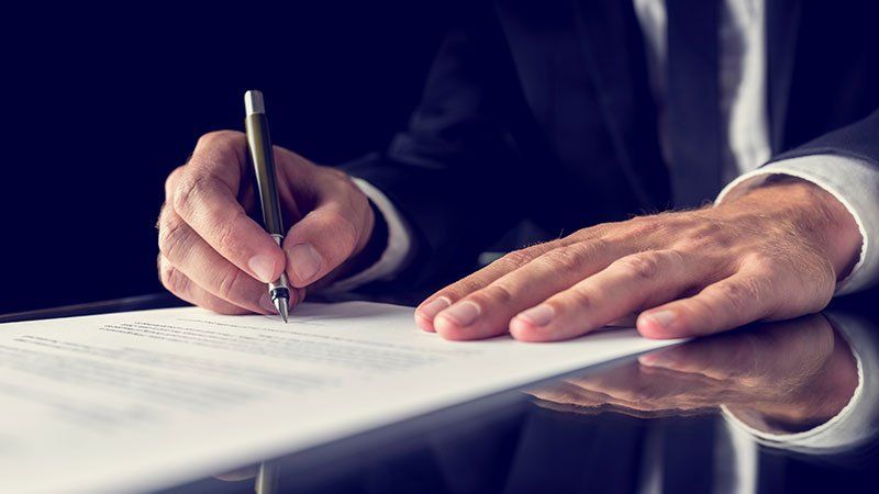 man writing something on a piece of paper