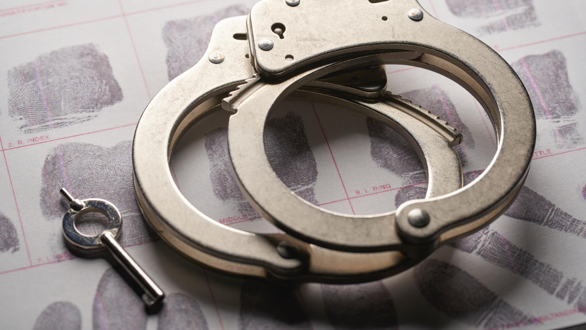 Handcuffs and key on top of fingerprint evidence.