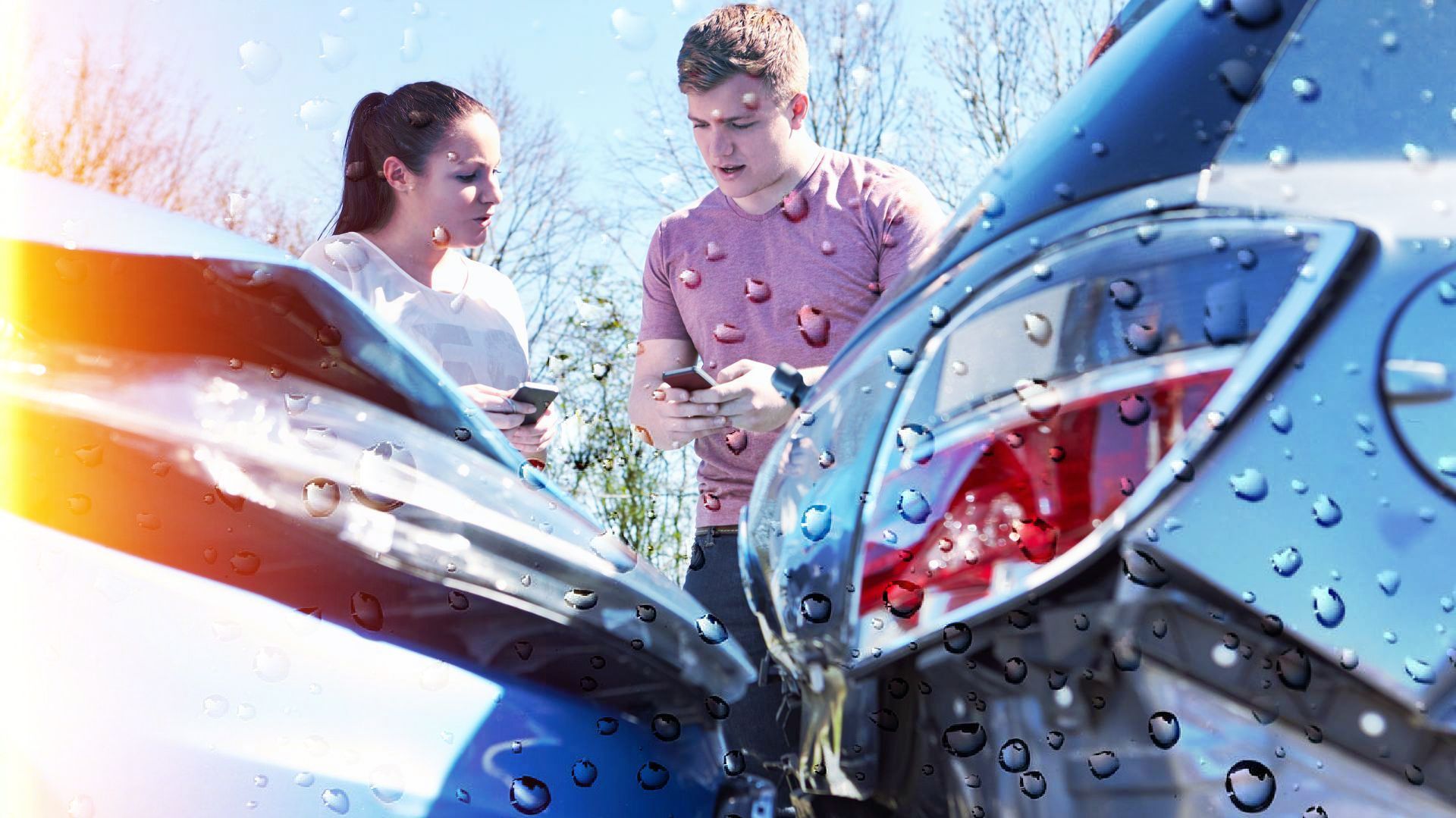 Two people examining car damage after a collision, possibly exchanging information.