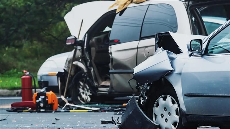 Cars involved in a collision; front-end damage to vehicles, debris on road.