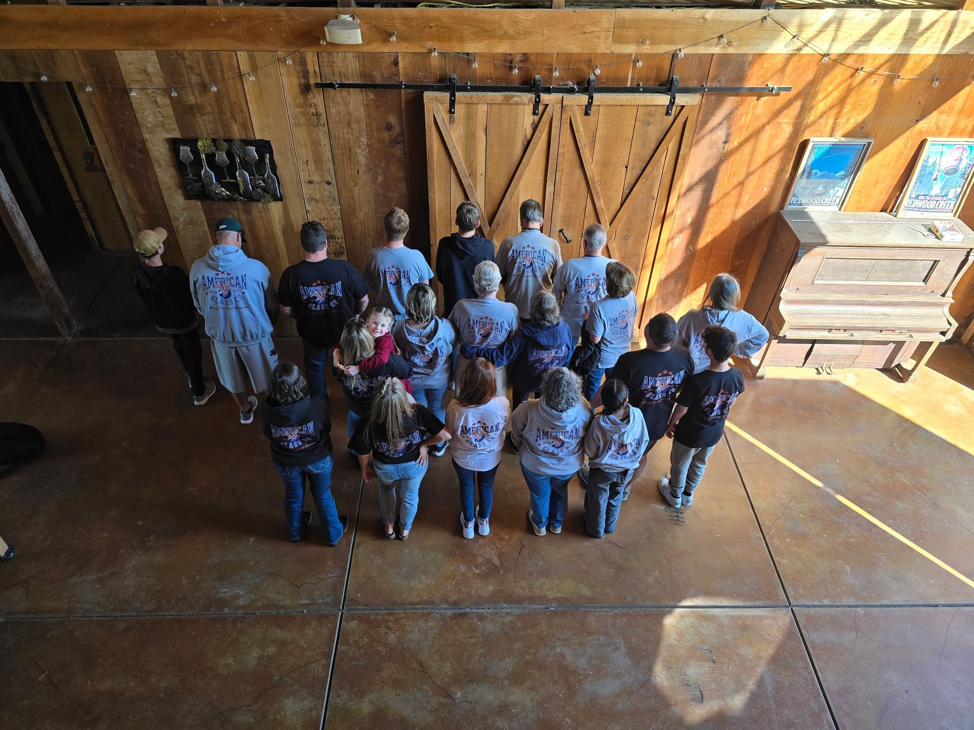 A group of people are standing in front of a barn door.