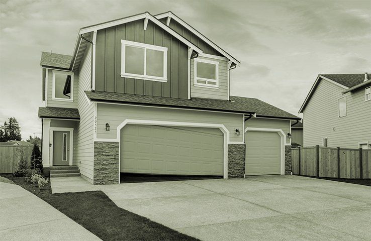 Suburban two-story house with a three-car garage and driveway, viewed from the street.