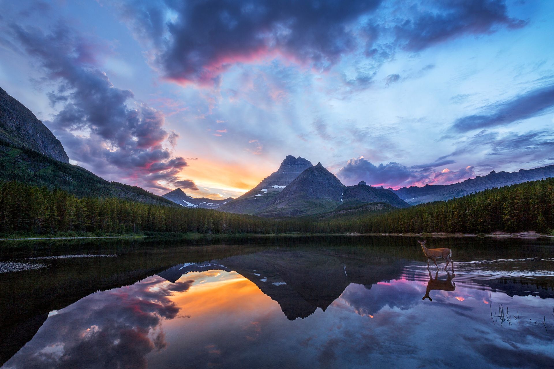 Sunset over mountain lake with vivid pink-blue sky and mirrored reflection