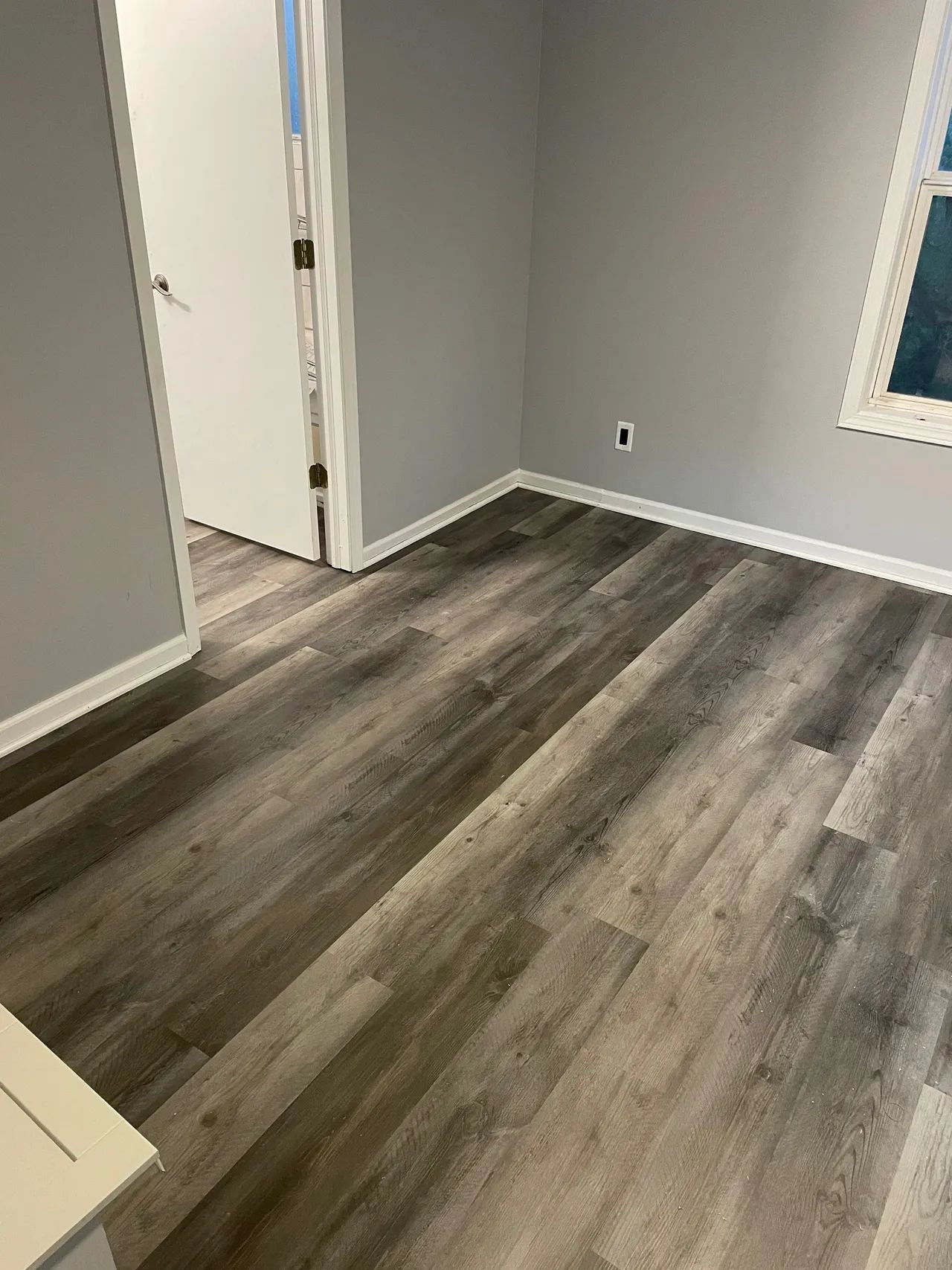 A room with a hardwood floor and a window.
