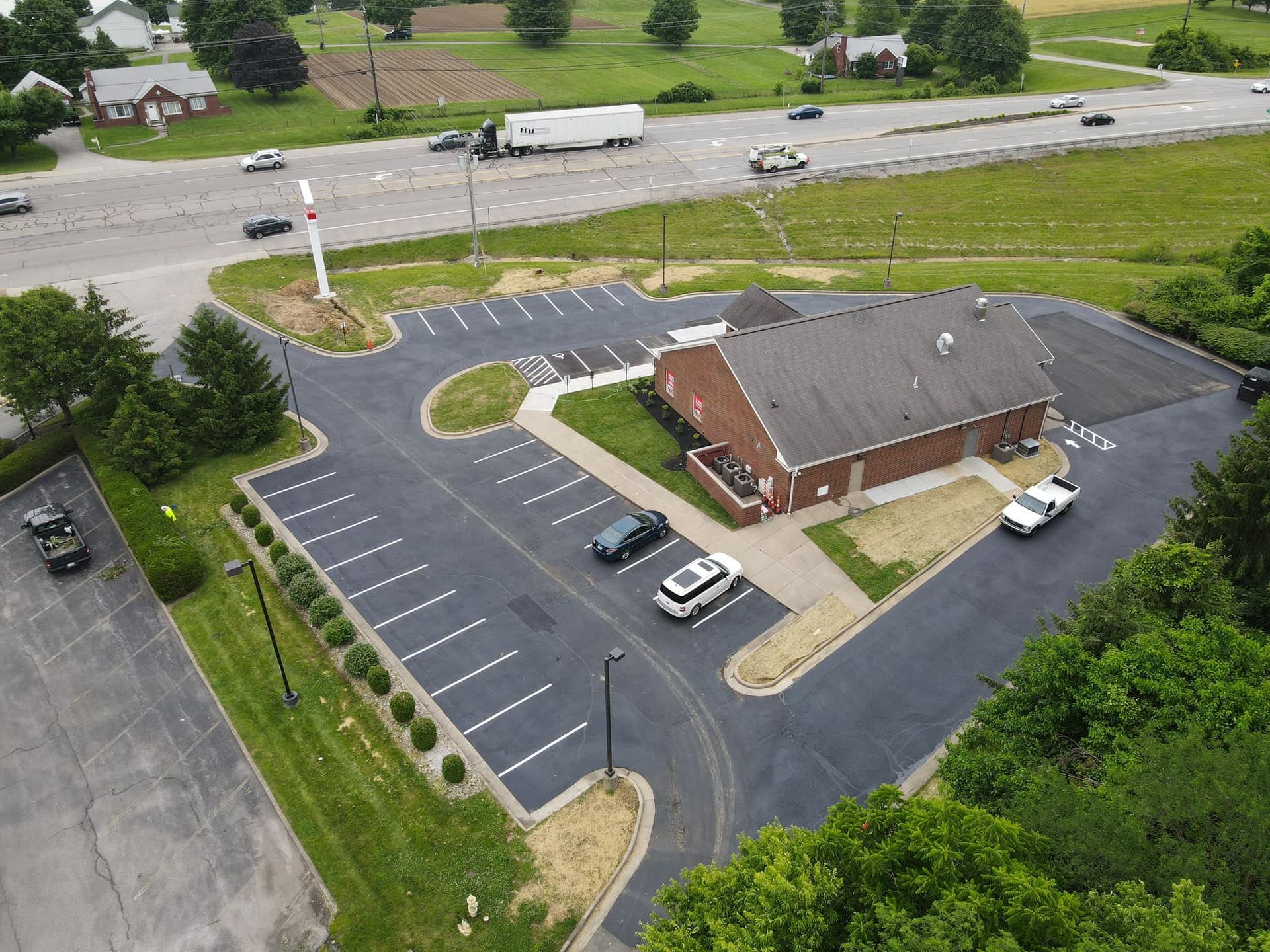 An aerial view of a parking lot with a building in the background