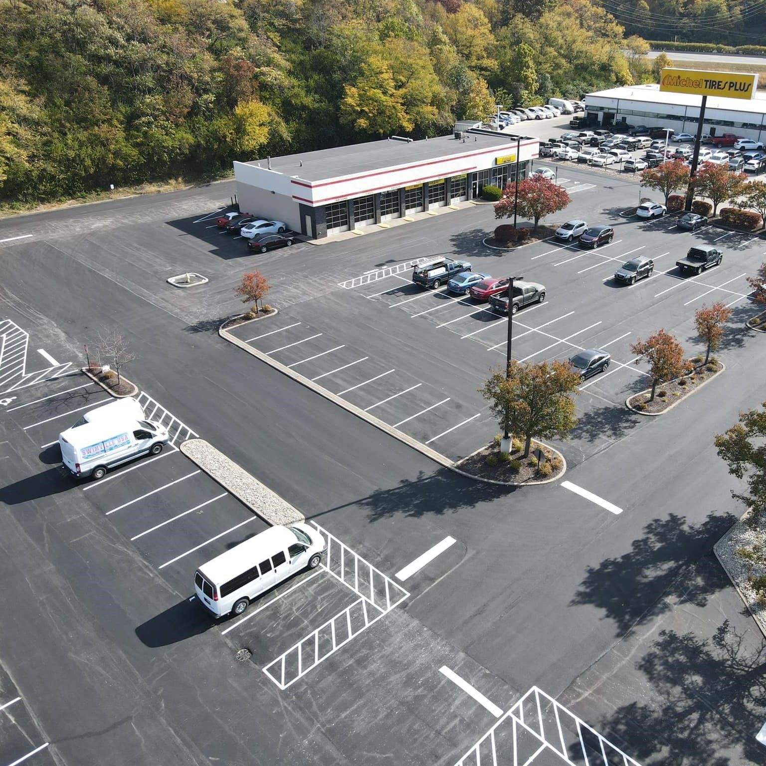 An aerial view of a parking lot with a store in the background