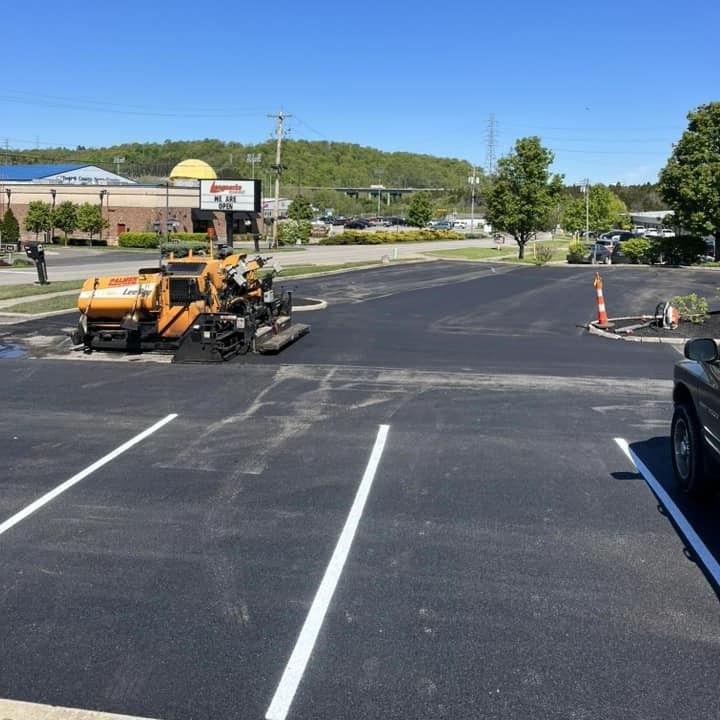 A car is parked in a parking lot next to a tractor