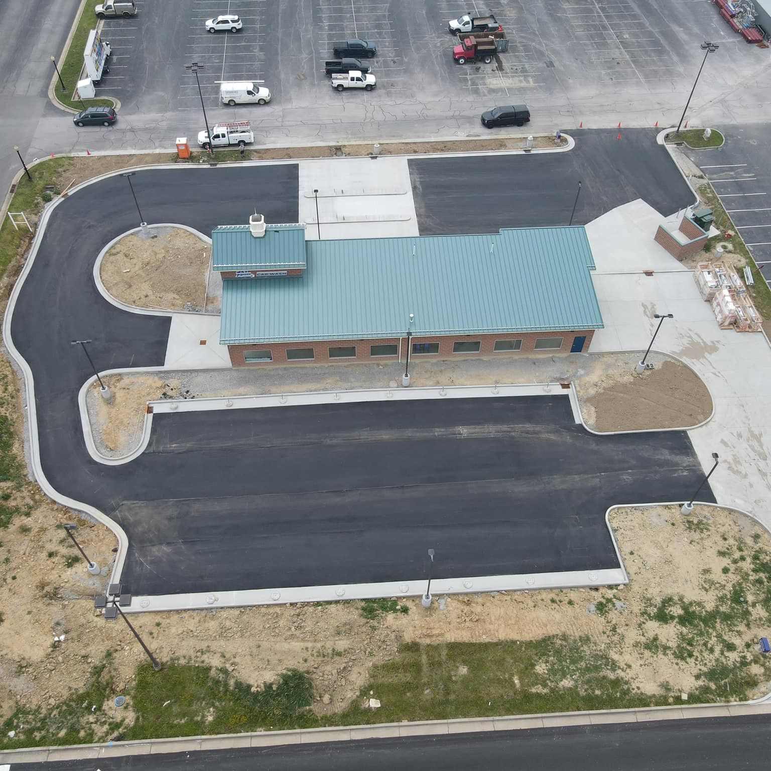 An aerial view of a parking lot with a building in the middle