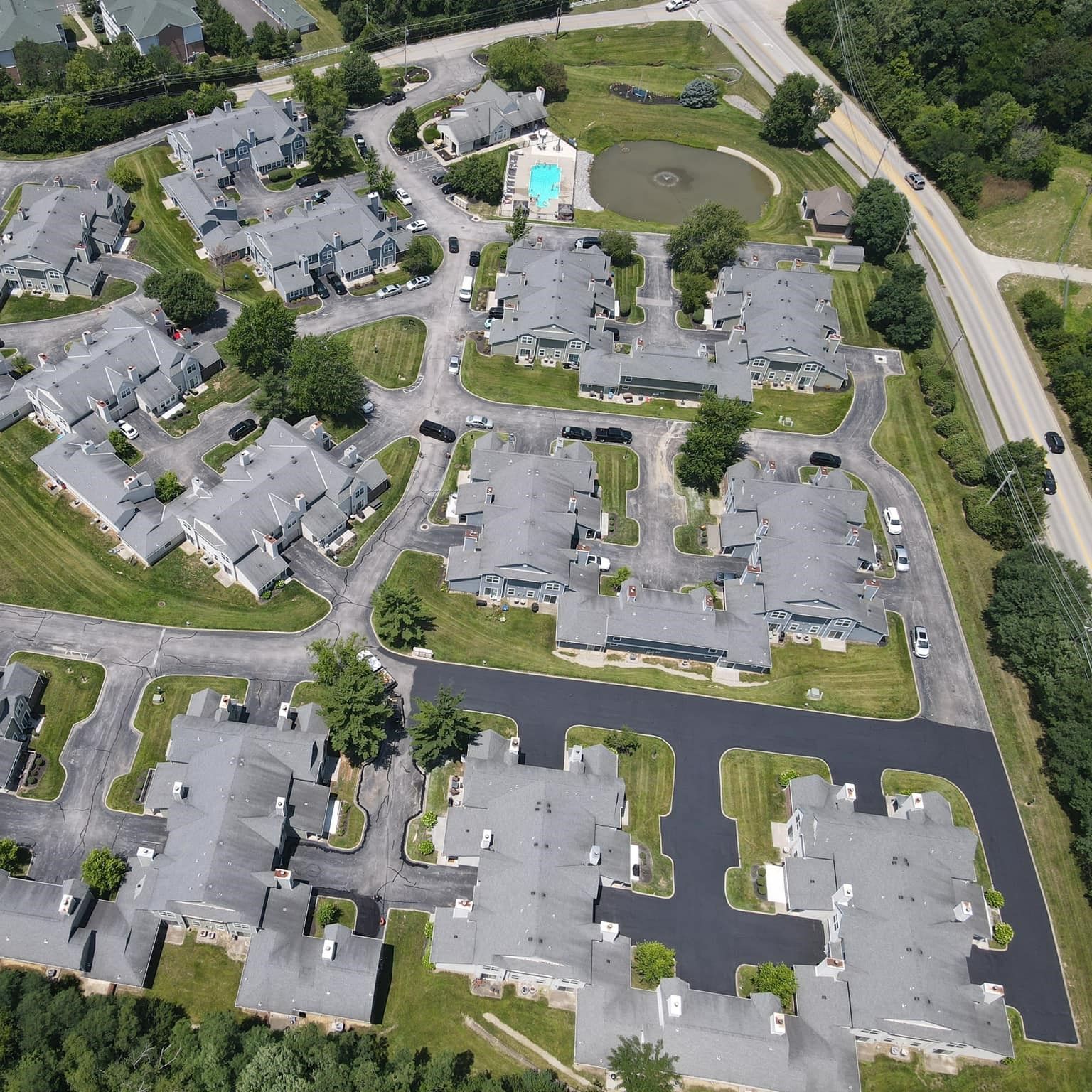 An aerial view of a residential area with a pool in the middle An aerial view of a residential area with a pool in the middle