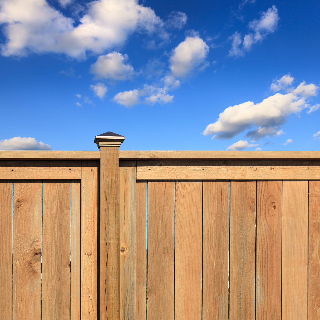 A wooden fence with a blue sky in the background