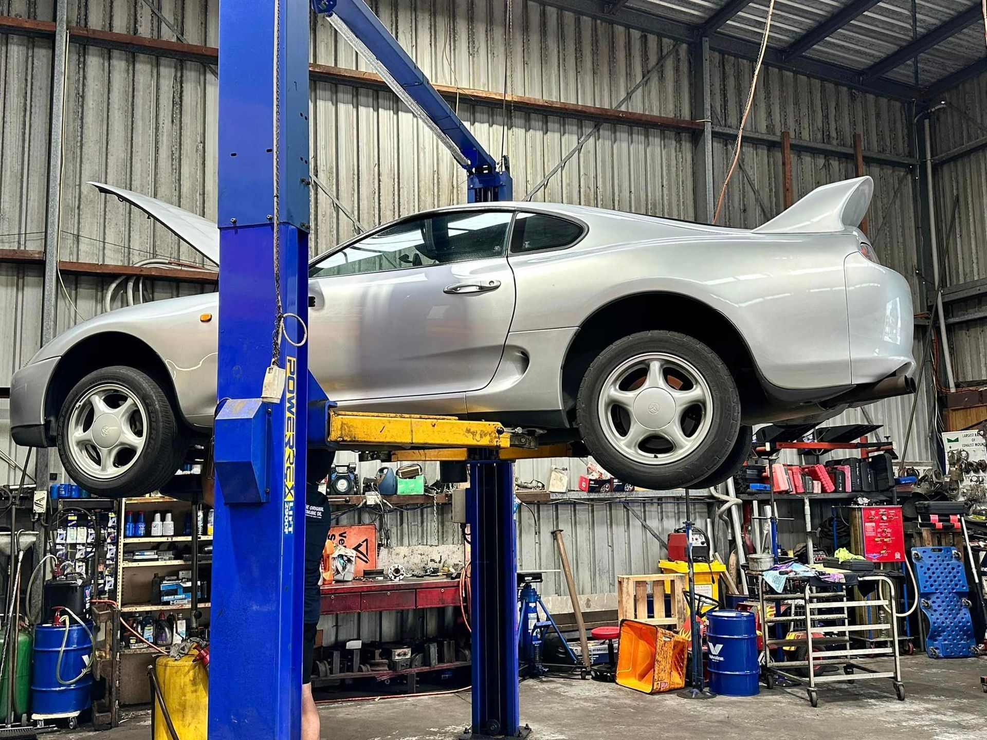 A car is sitting on a lift in a garage. — One Stop Service and Suspension Centre In Port Macquarie, NSW