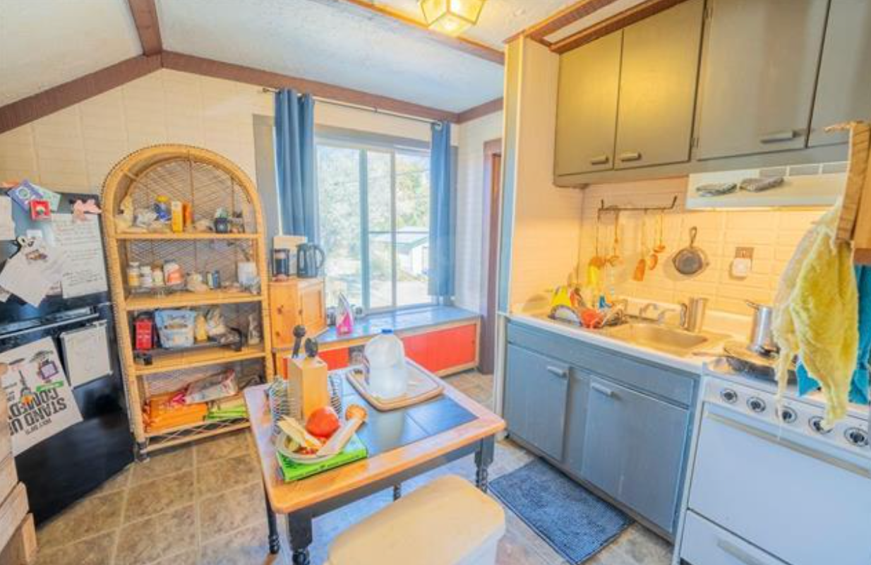 Bright kitchen with blue cabinets, dining table, and sunlight through a window
