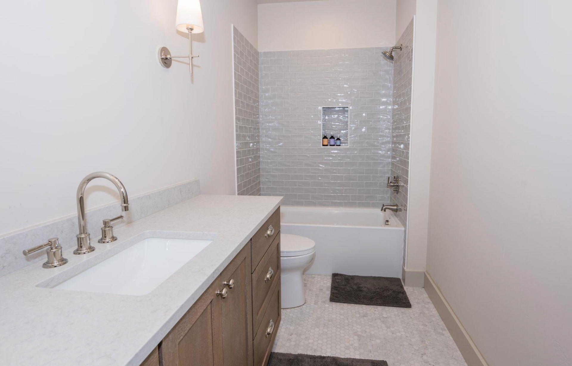 Bright bathroom with white vanity, tub-shower, and tiled floor and wall.