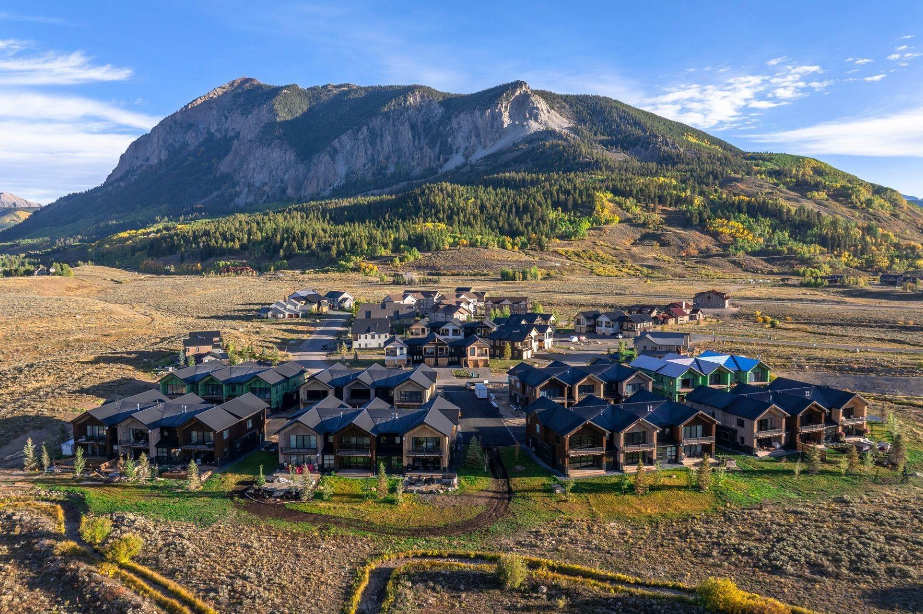 Mountain overlooking a suburban neighborhood under a clear blue sky
