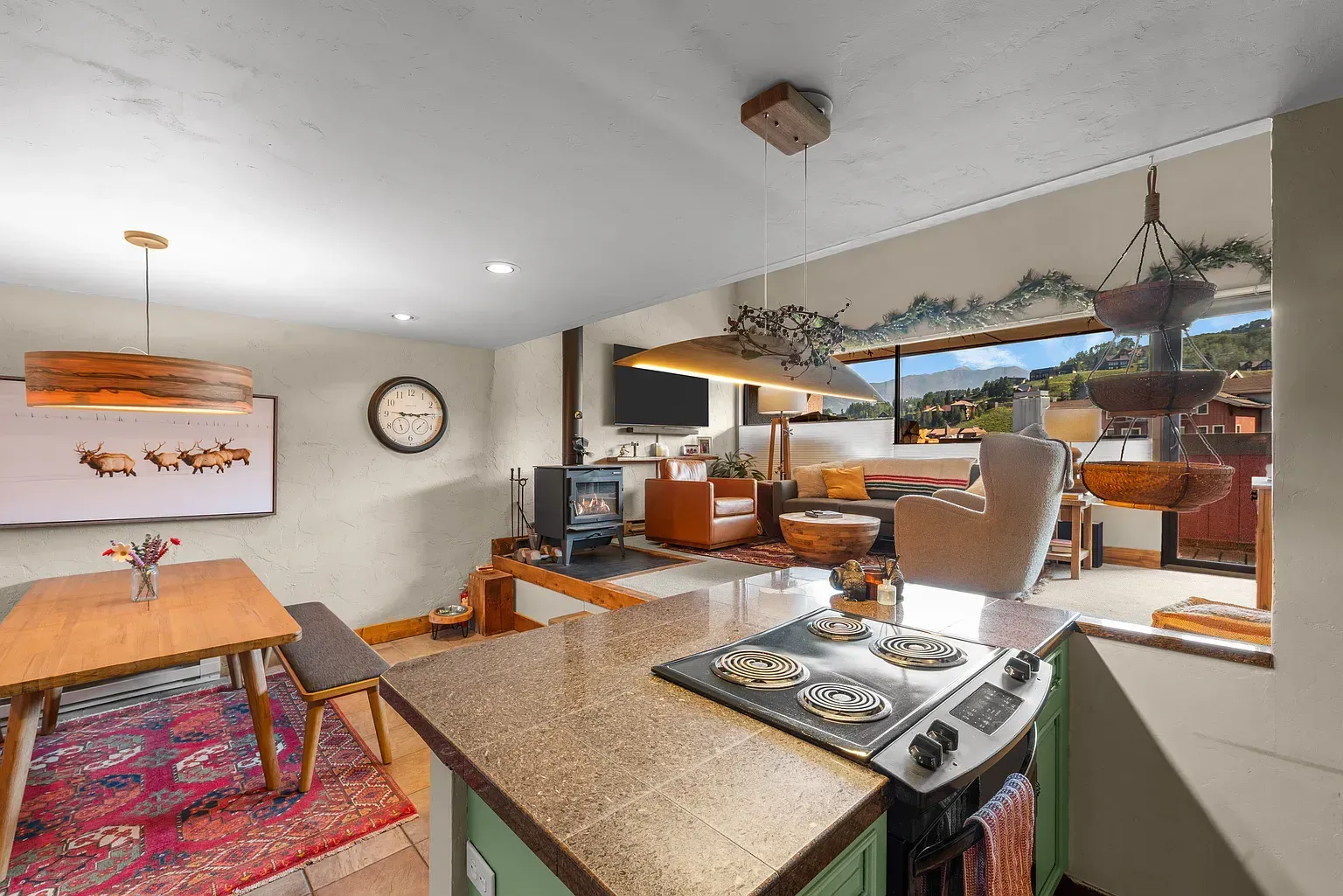 Modern kitchen and dining area with open pass-through to a bright sunroom and outdoor seating.