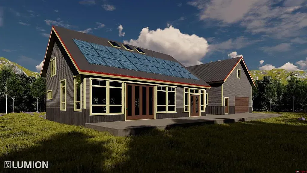 Modern house with solar panels on a roof in a sunny grassy setting