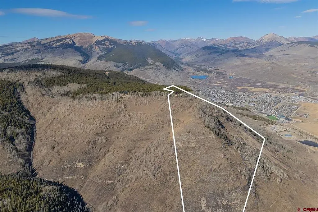 Aerial view of a forested mountain ridge with a white outline marking land boundaries.