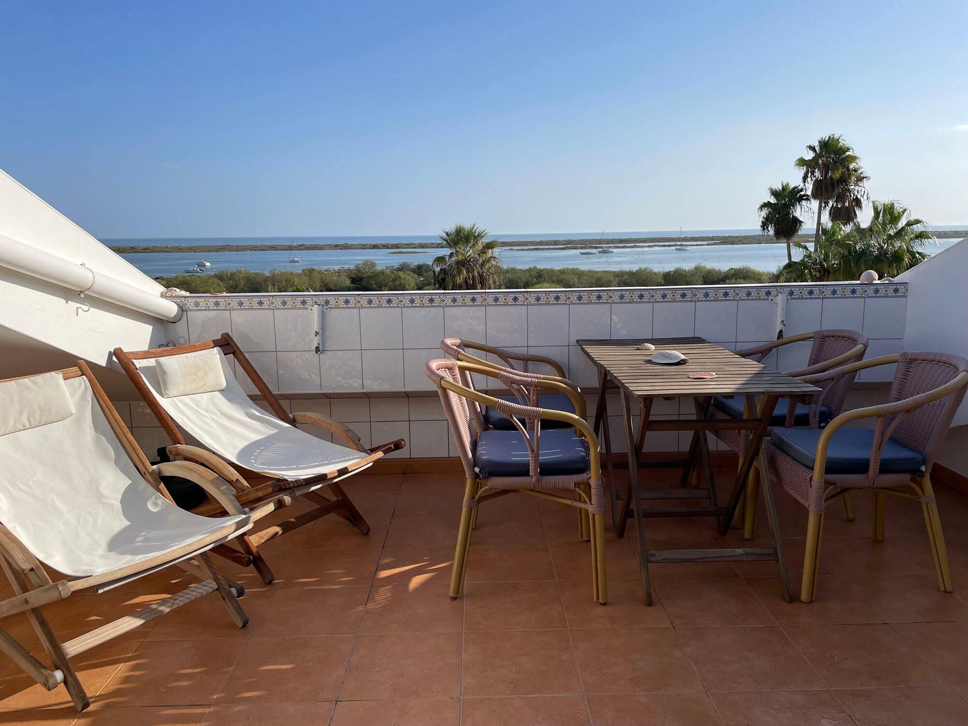 Ein Balkon mit Stühlen und Tisch mit Blick auf das Meer