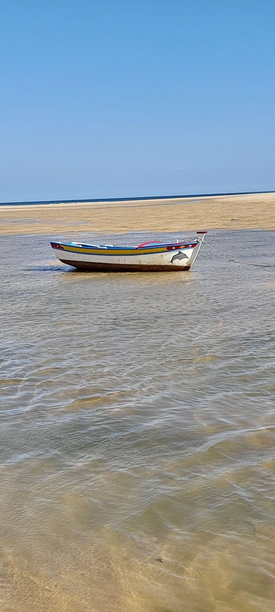 Ein kleines Boot schwimmt auf einer Wasserfläche an der Algarve