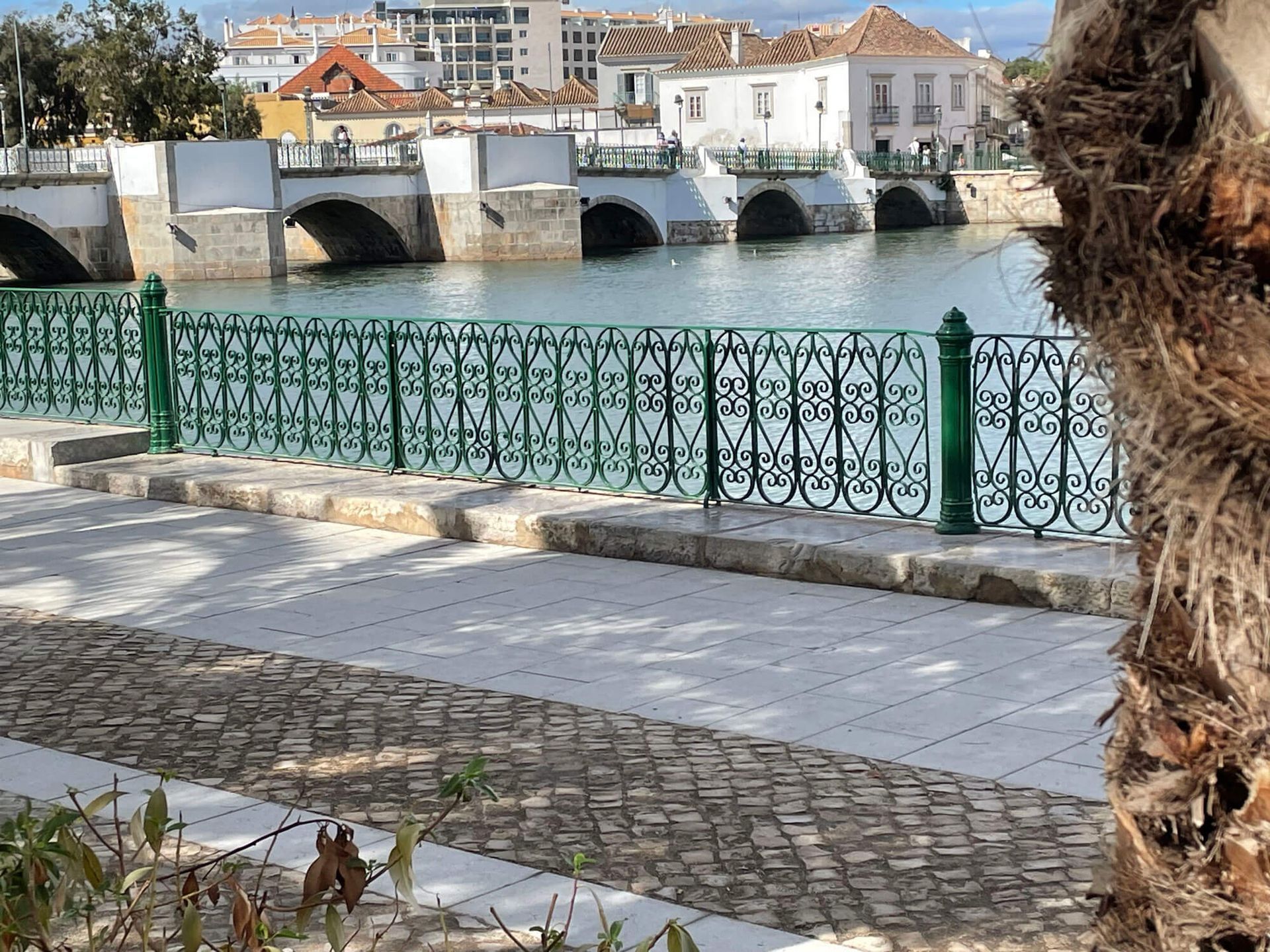 Tavira: eine Brücke über ein Gewässer mit Gebäuden im Hintergrund