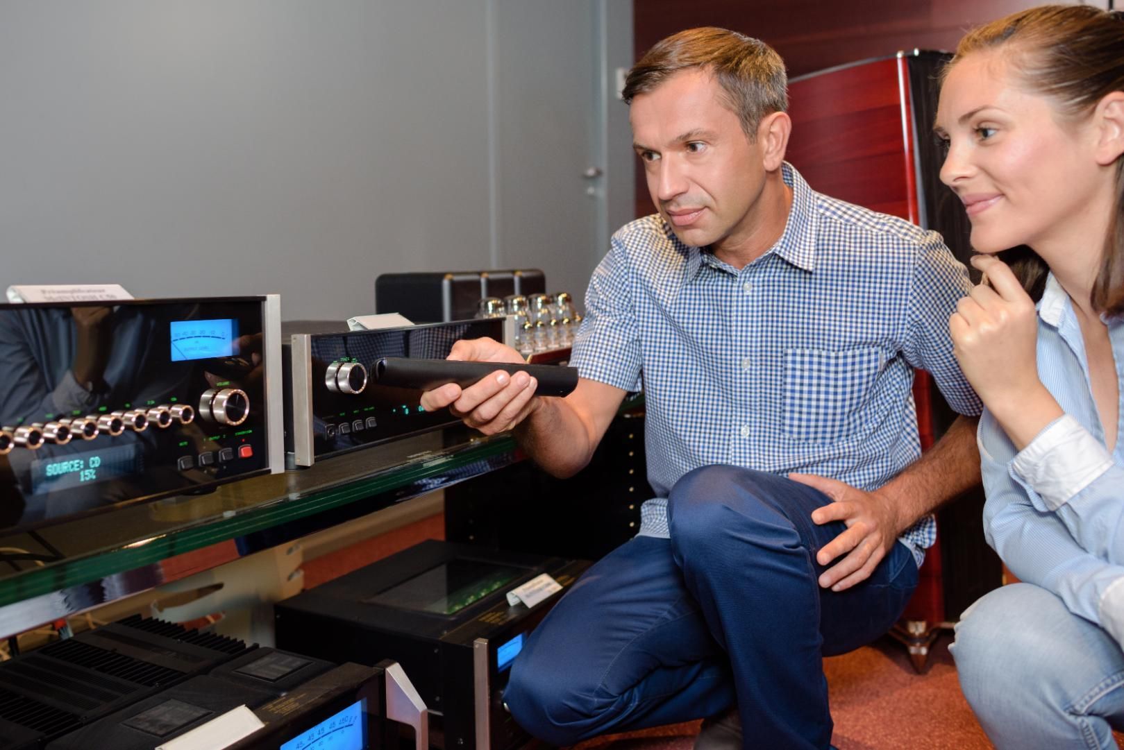 Two people examining equipment with gauges and controls in a lab or workshop setup.