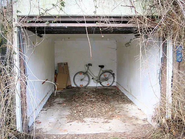A bicycle is parked in an empty garage.