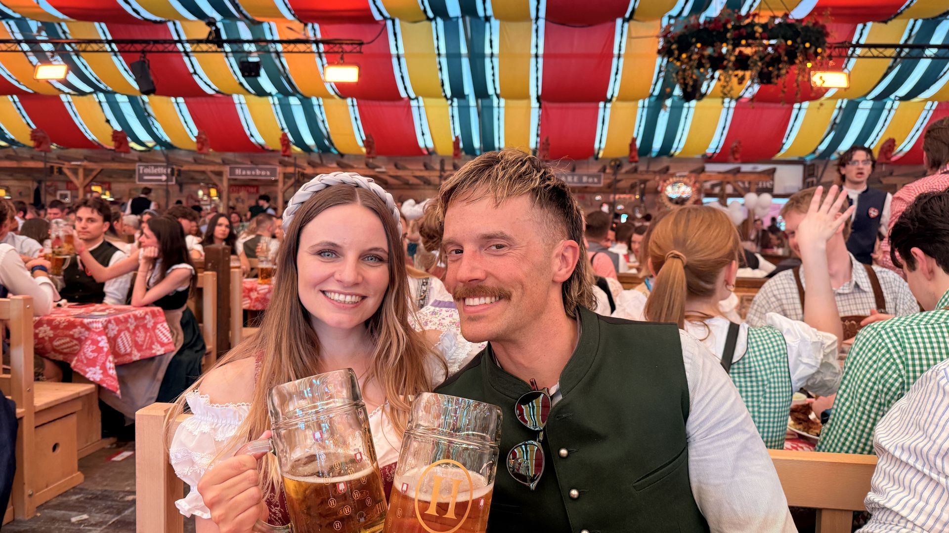 Bavarian outfits with 1 liter beer glasses at a Munich beer festival