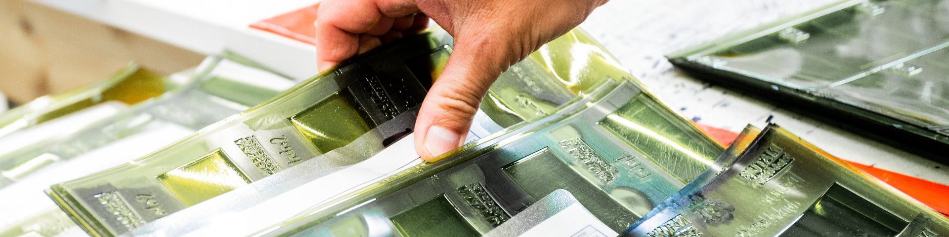 Eine Hand steckt Euro-Banknoten in ein Portemonnaie neben verstreutem Bargeld und einem Taschenrechner.