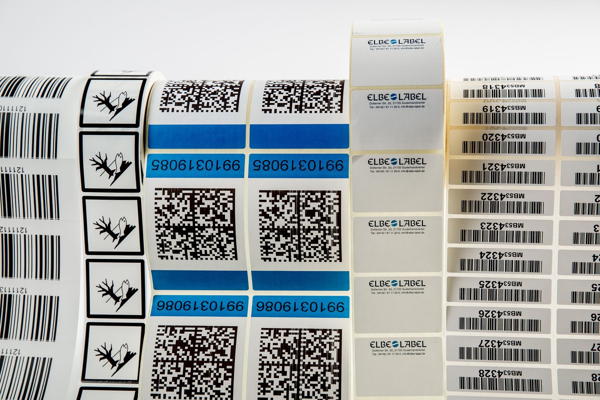 Reihen von blau und weiß bedruckten Etiketten mit QR-Codes und Barcodes auf Rollen