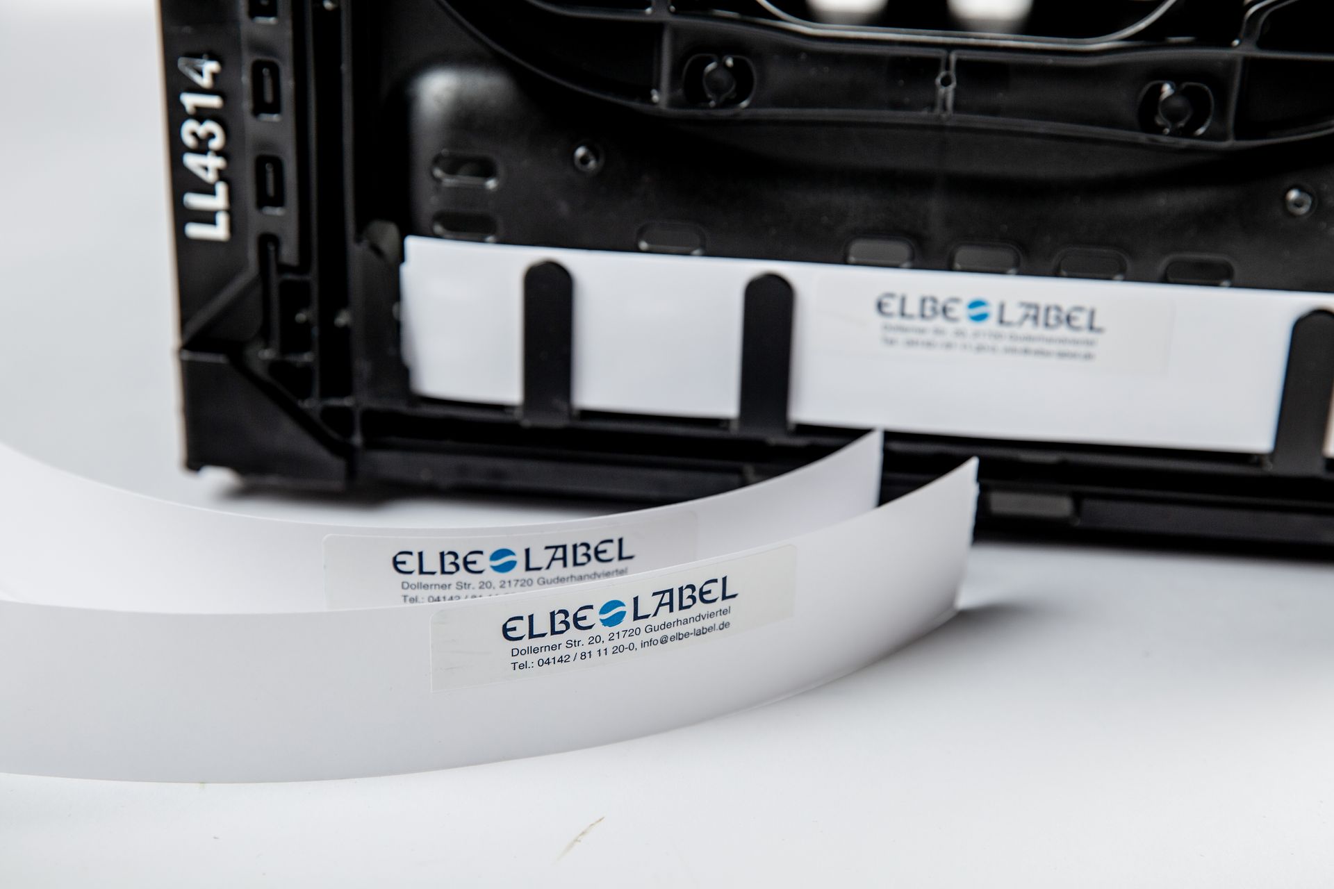 Etikettendrucker druckt weiße ELBE & LABEL-Aufkleber auf einer Produktionsmaschine