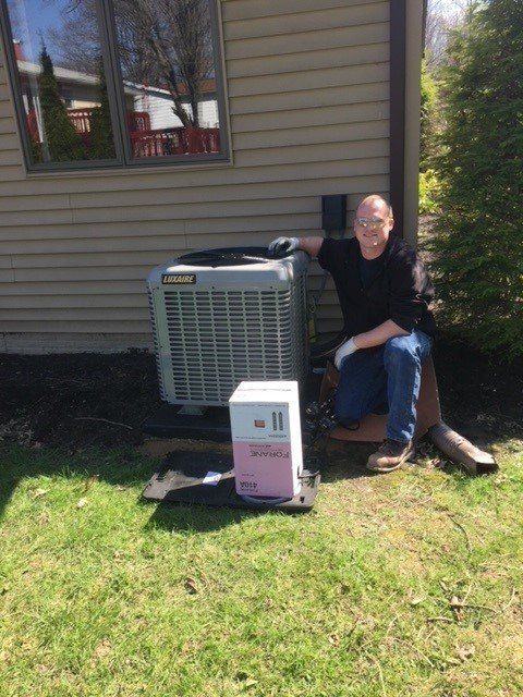Man Beside HVAC Unit — Ashtabula, OH — Blank Heating Company Inc