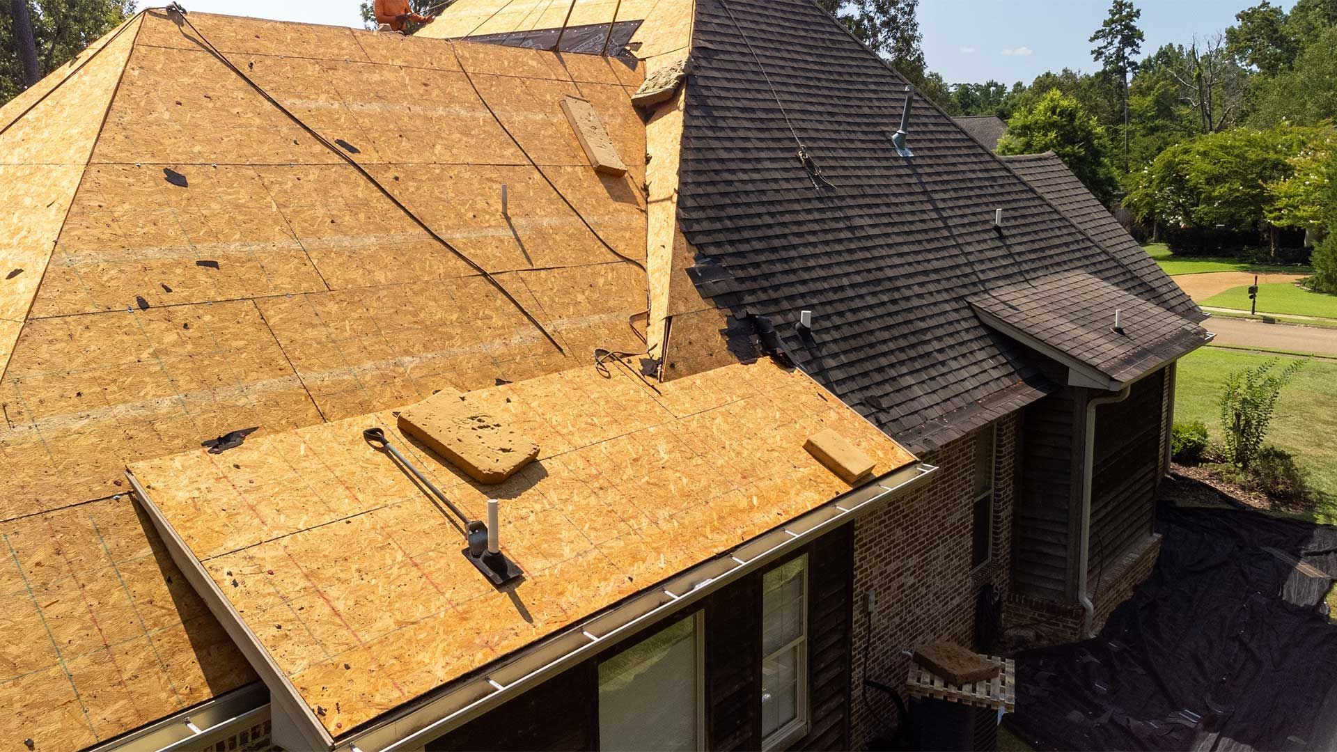 An aerial view of a house with a roof that is being repaired.