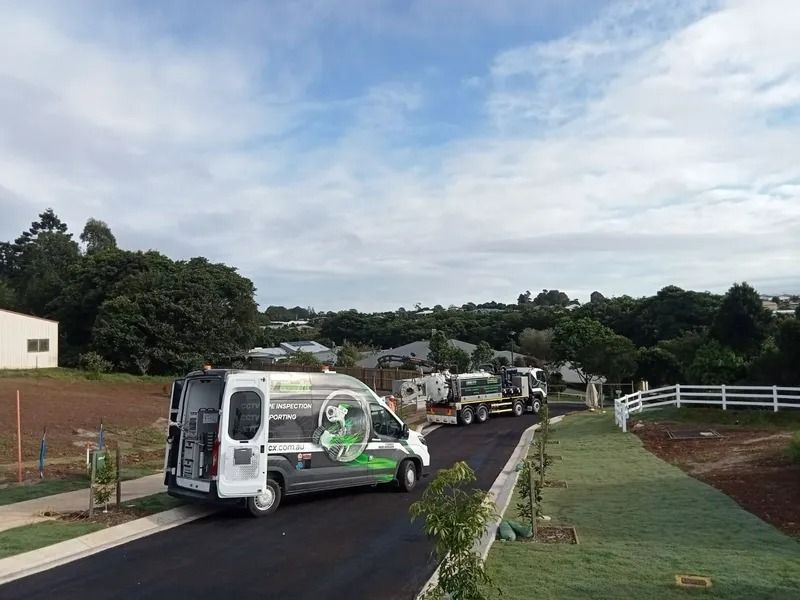 A White Van and Truck Parked on a Road Lined With Grass — Tyzac Group in Beerwah, QLD