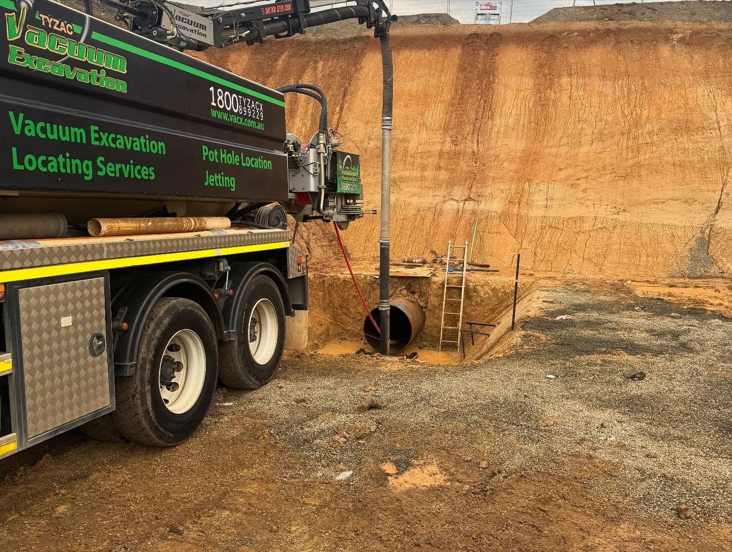 Truck With Vacuum Hose Excavating Near a Pipe — Tyzac Group in Beerwah, QLD