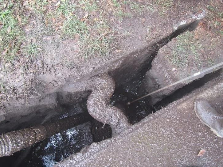 Open Trench With Wastewater and a Flexible Pipe; a Worker's Boot is Visible — Tyzac Group in Beerwah, QLD