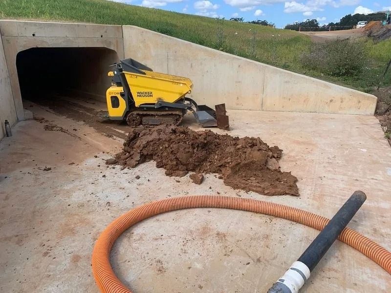 Yellow Track Dumper in Tunnel Exit, Dumping Mud Onto Concrete — Tyzac Group in Beerwah, QLD