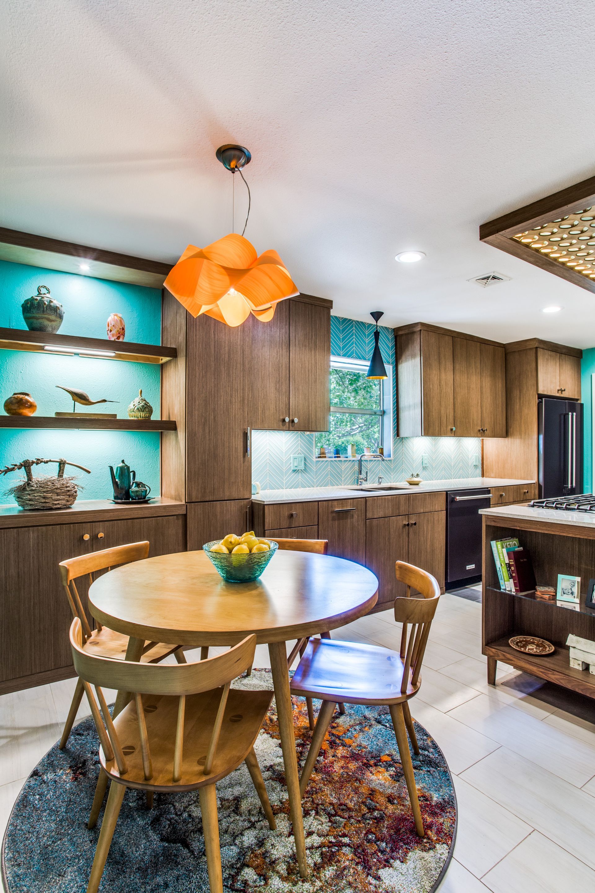A kitchen with a round table and chairs in it.