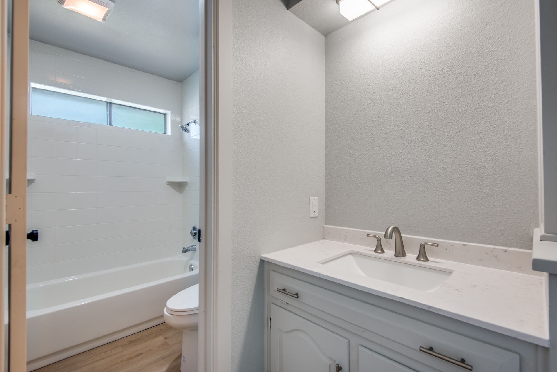 A bathroom with a sink , toilet and bathtub.