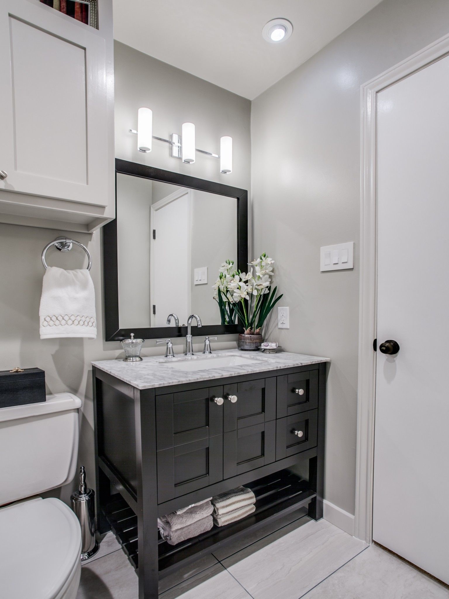 A bathroom with a sink , toilet and mirror.