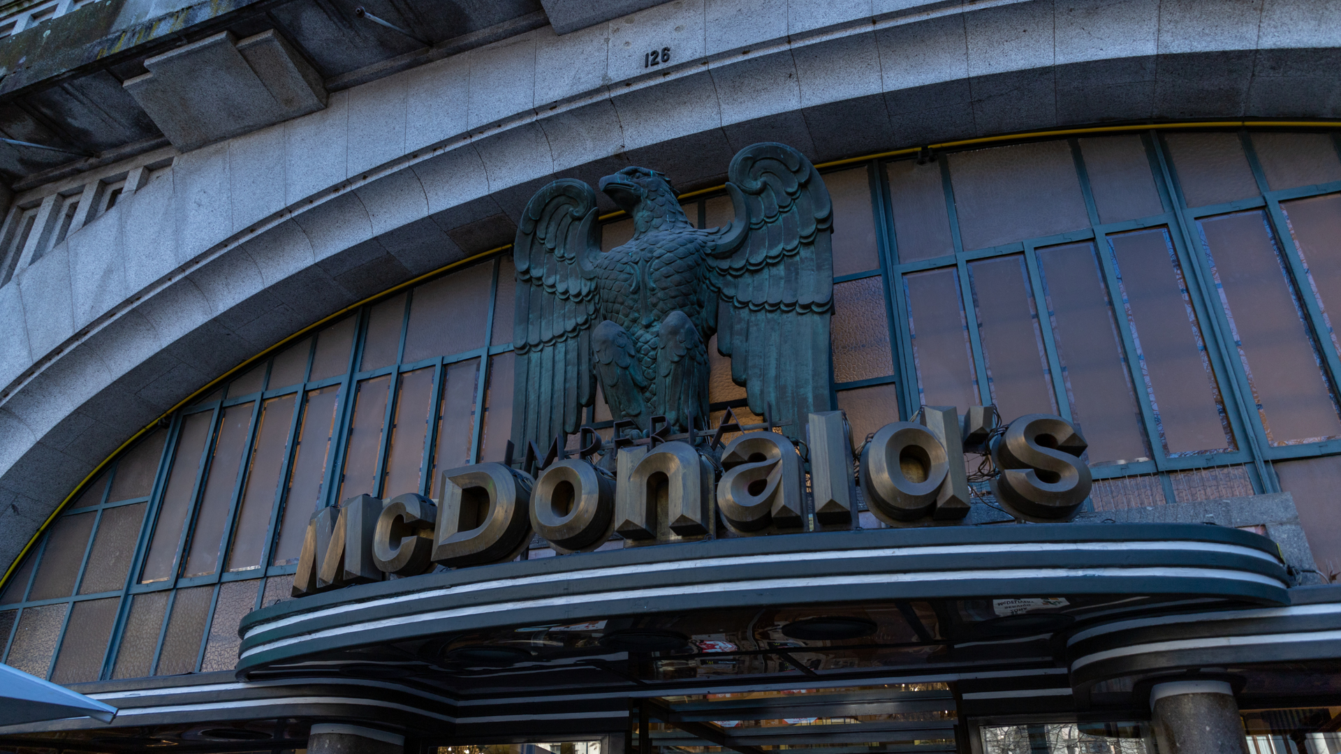 McDonald's sign with bronze eagle on an ornate building facade.