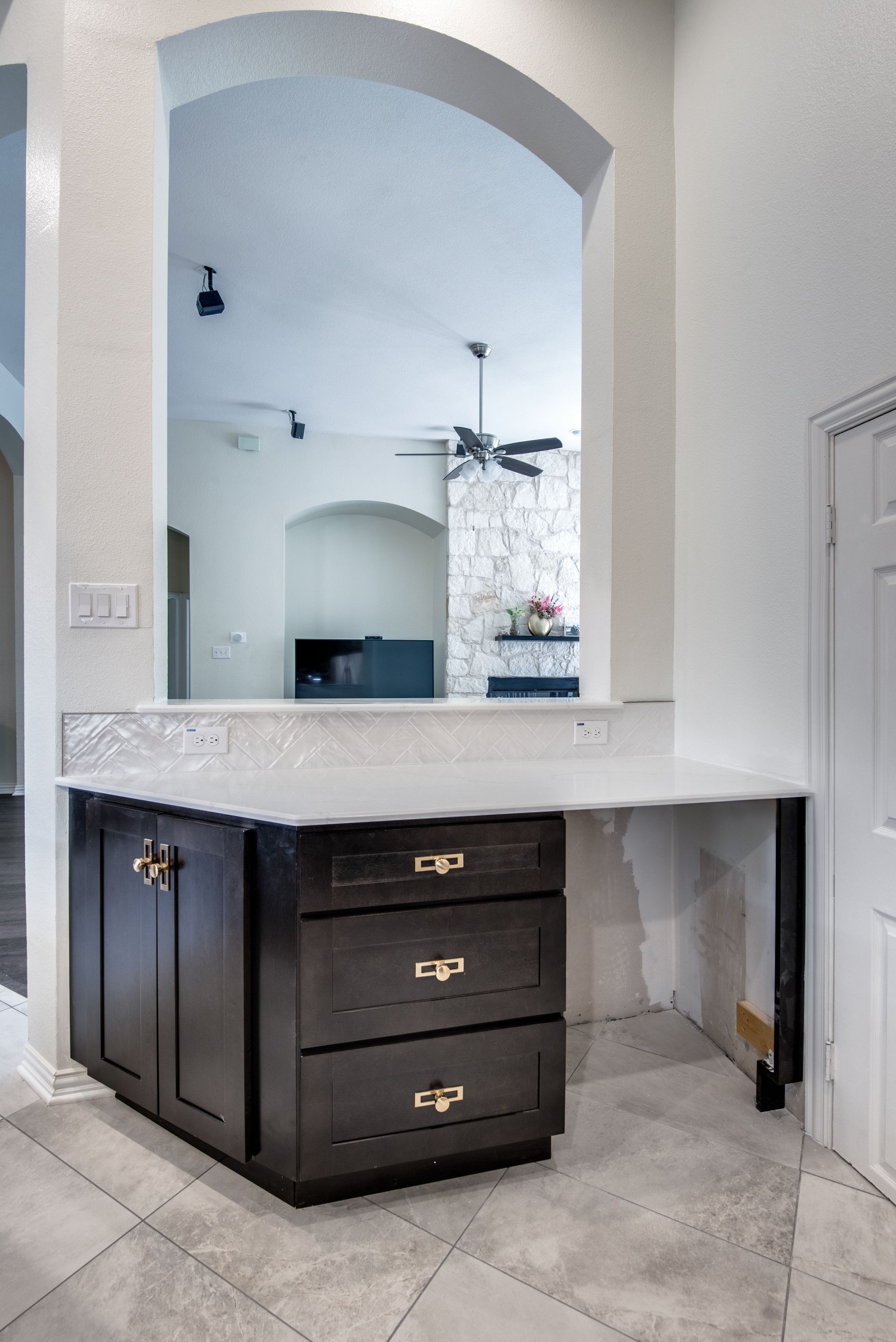 A kitchen with black cabinets and a white counter top.