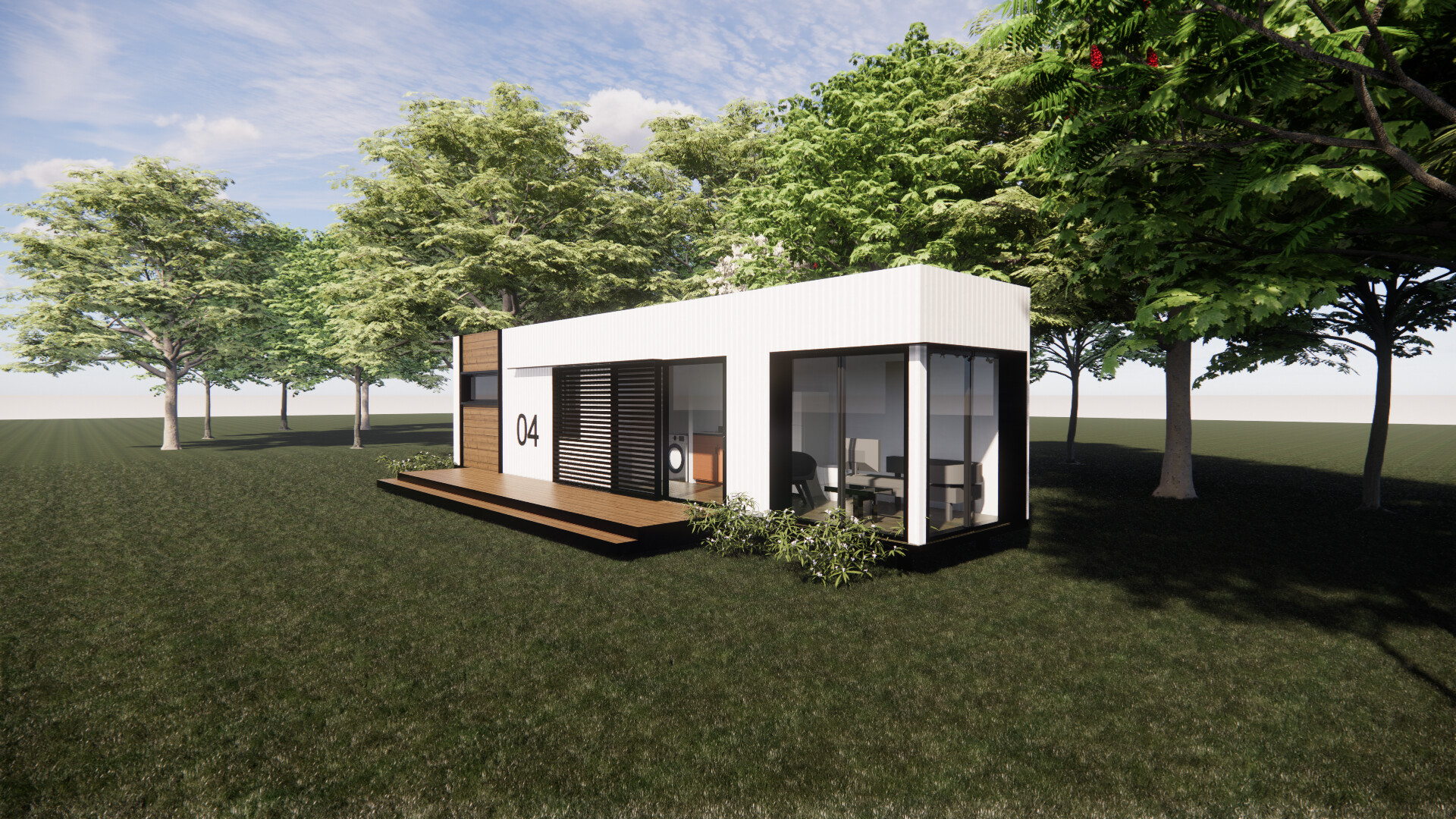 A small shipping container white house is sitting in the middle of a grassy field surrounded by trees.