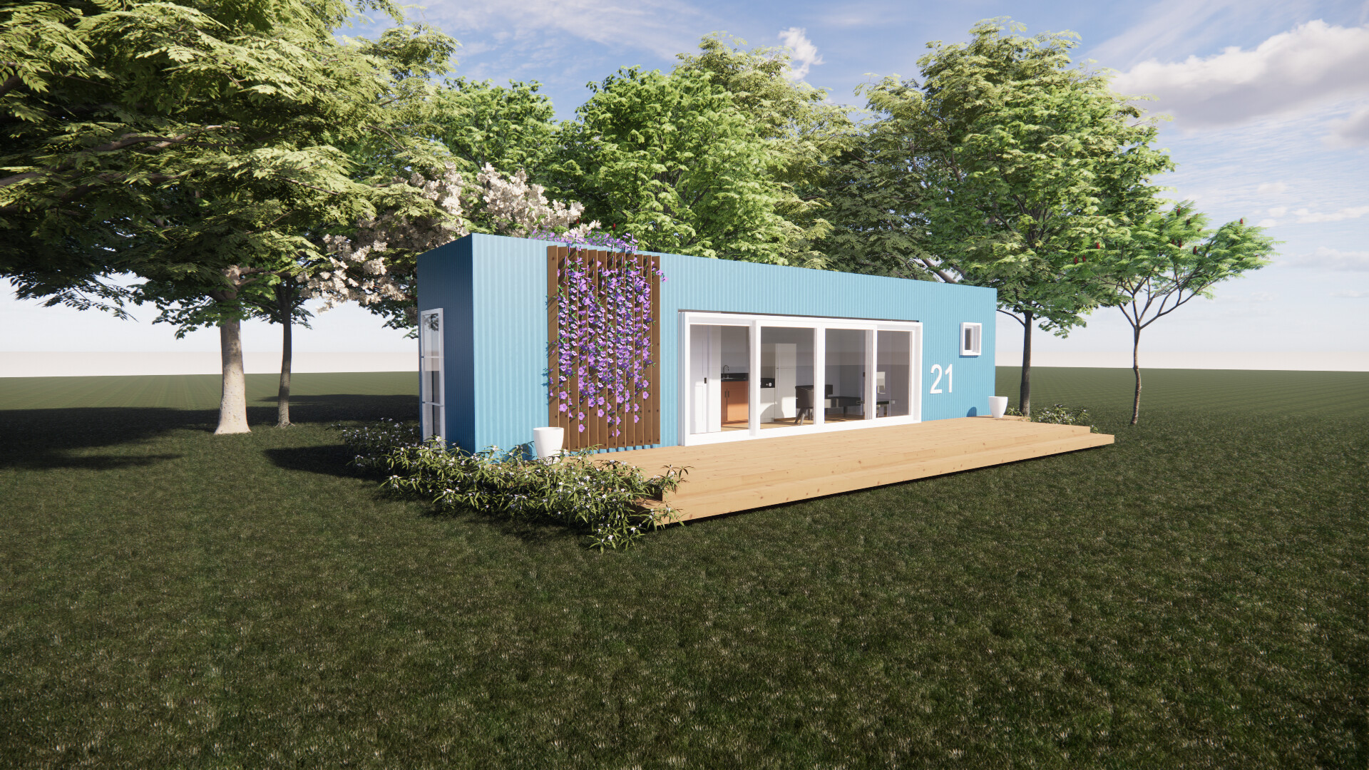A blue shipping container house with a wooden deck is sitting in the middle of a field surrounded by trees.