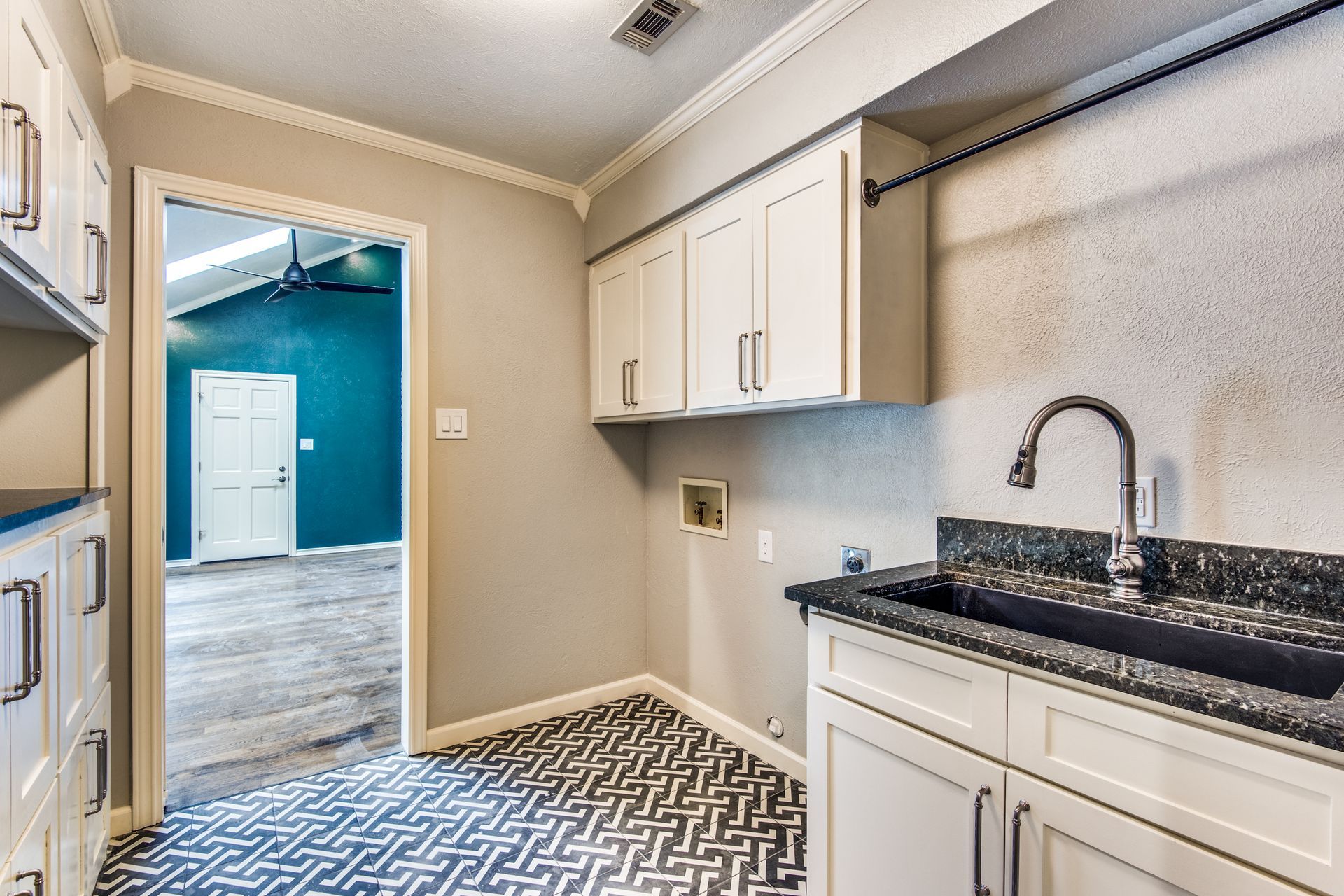 A  Plano home remodel  laundry room with a sink , cabinets , and a patterned floor.