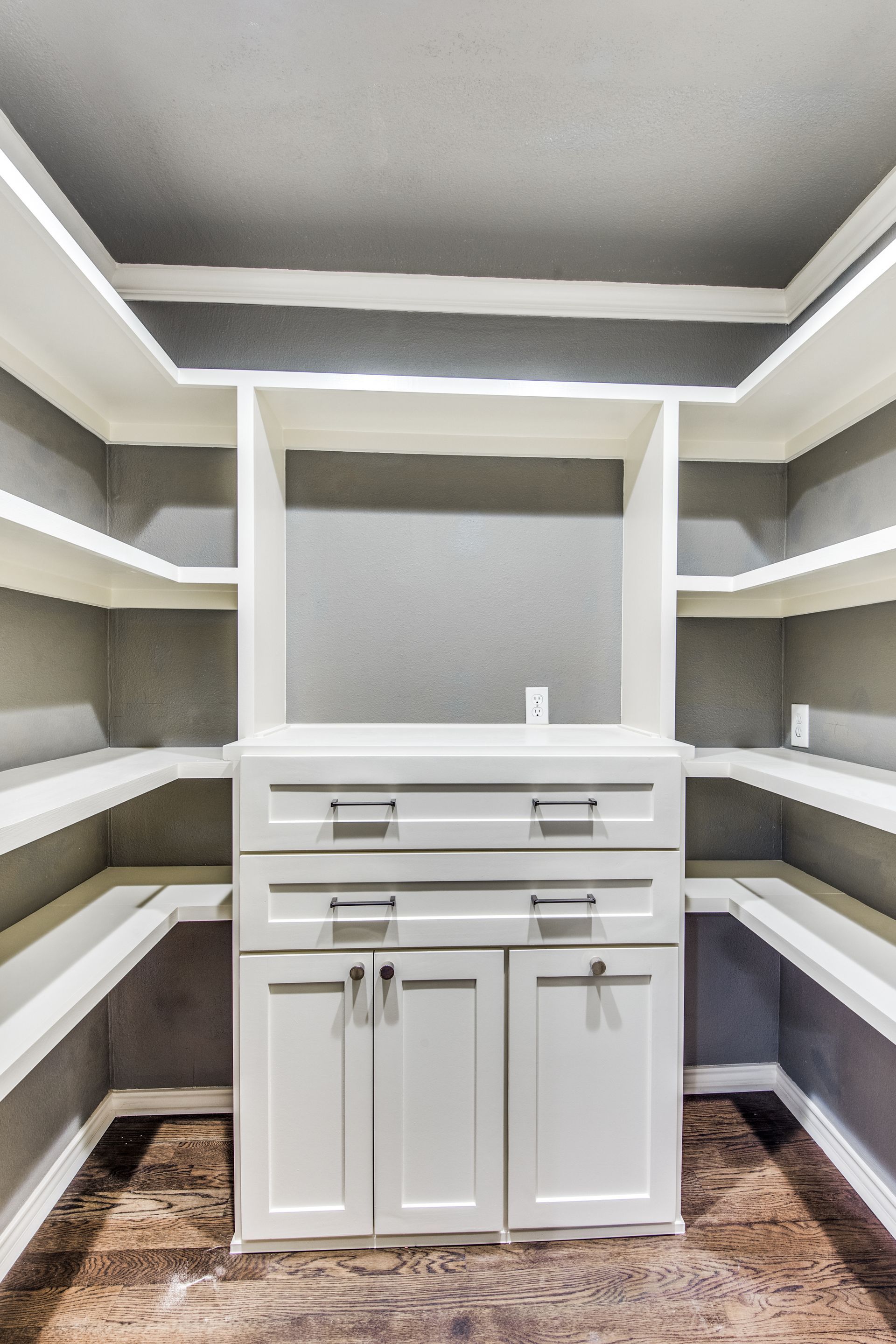 A Plano home remodel walk in closet with lots of shelves and cabinets.