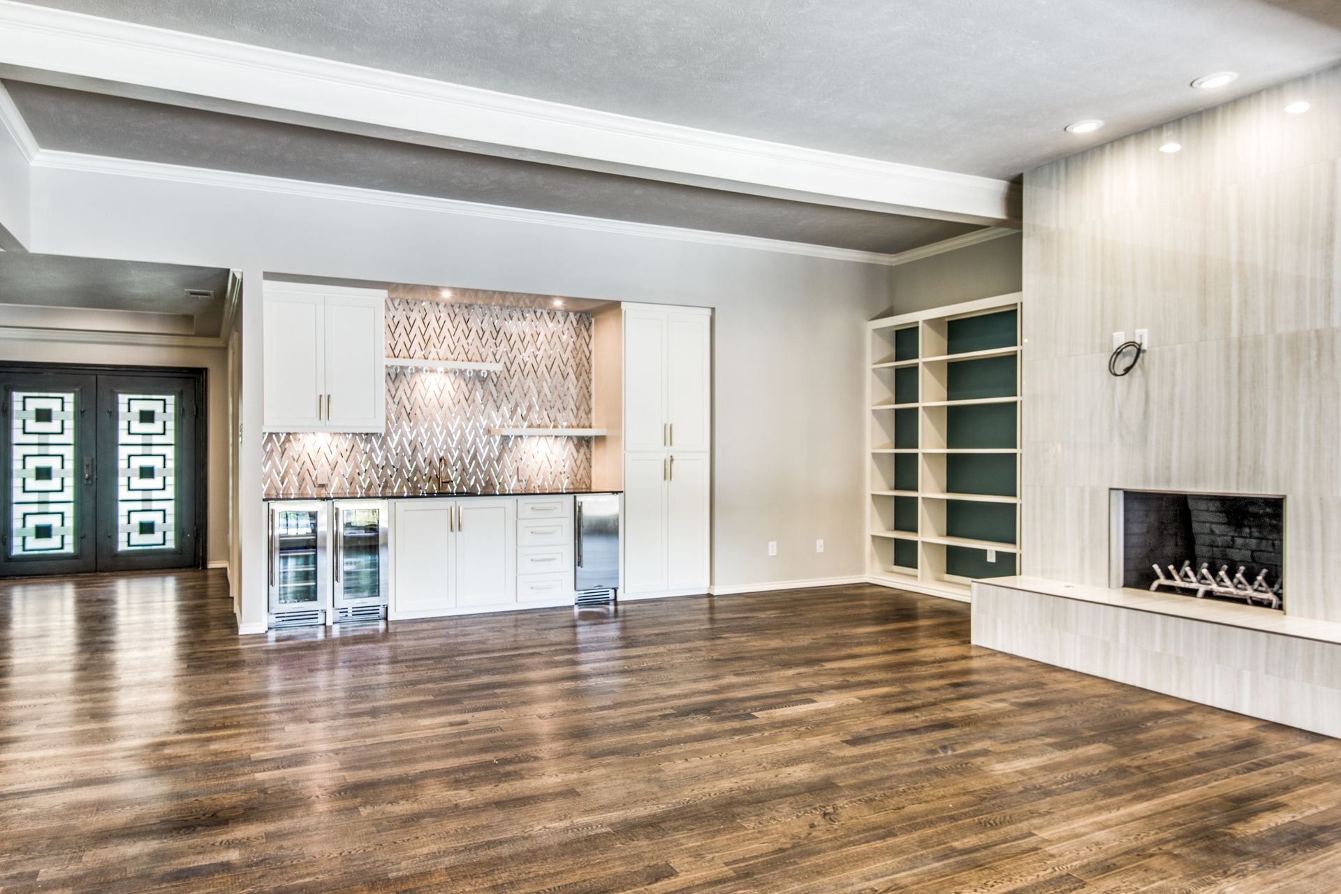 A Plano home remodel empty living room with hardwood floors and a fireplace