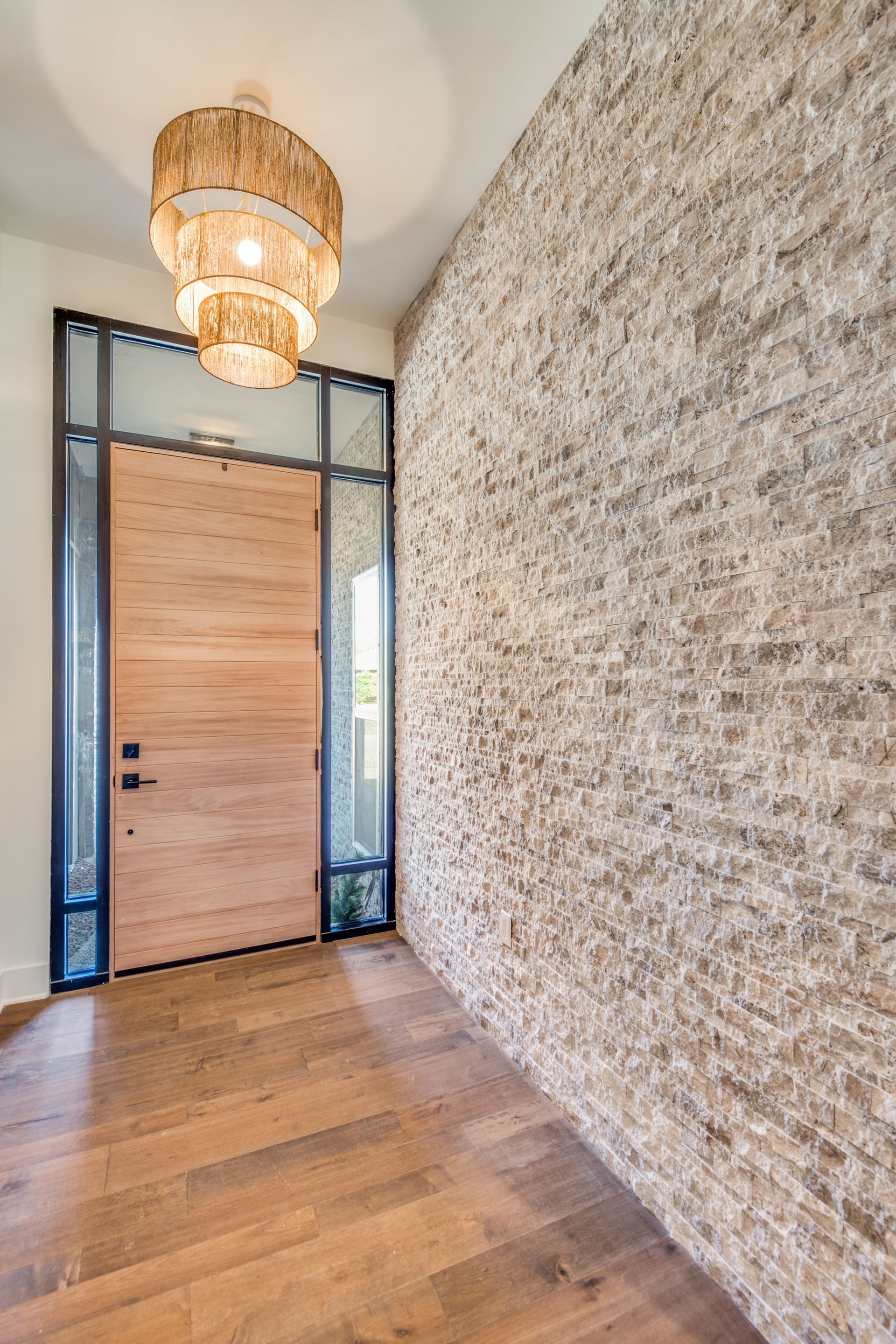 A hallway with a wooden door and a brick wall.